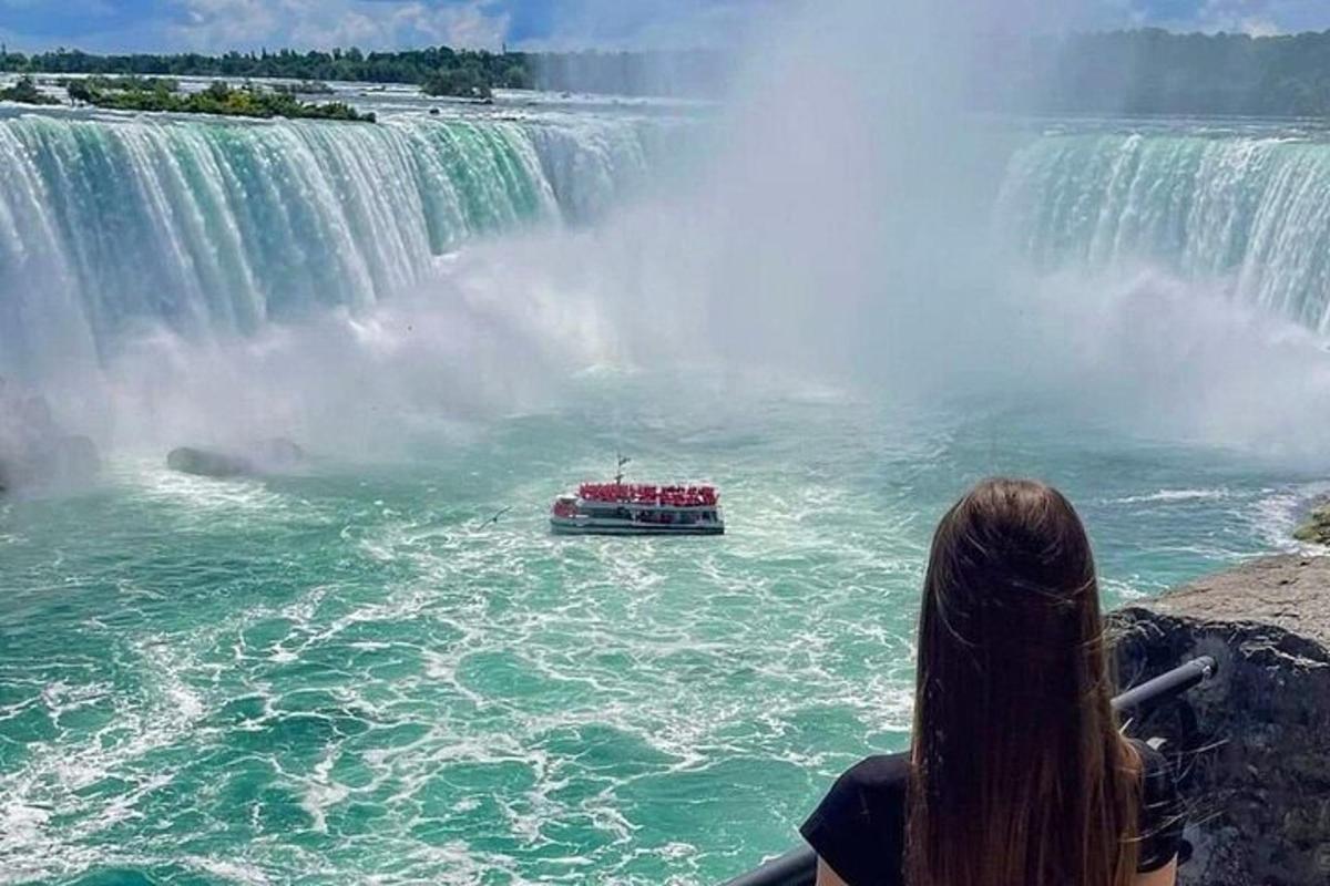 a girl watching a boat in the water at niagara falls