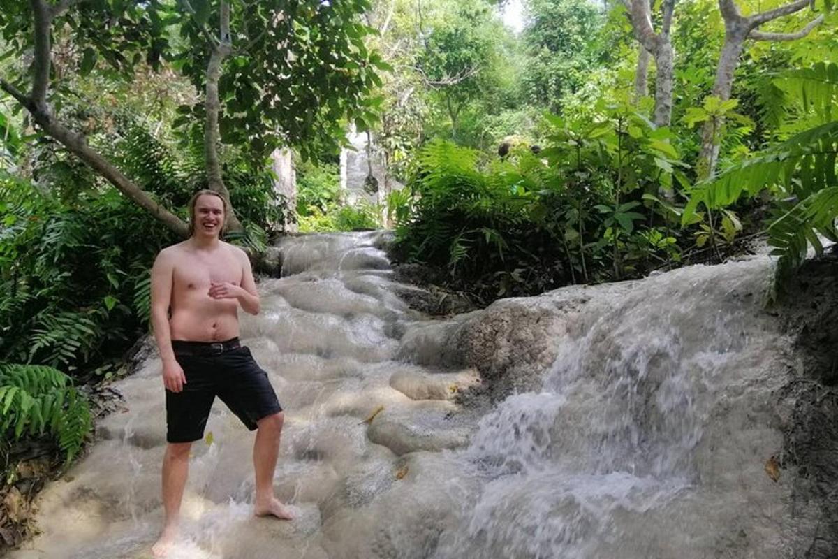 a man standing in front of a waterfall