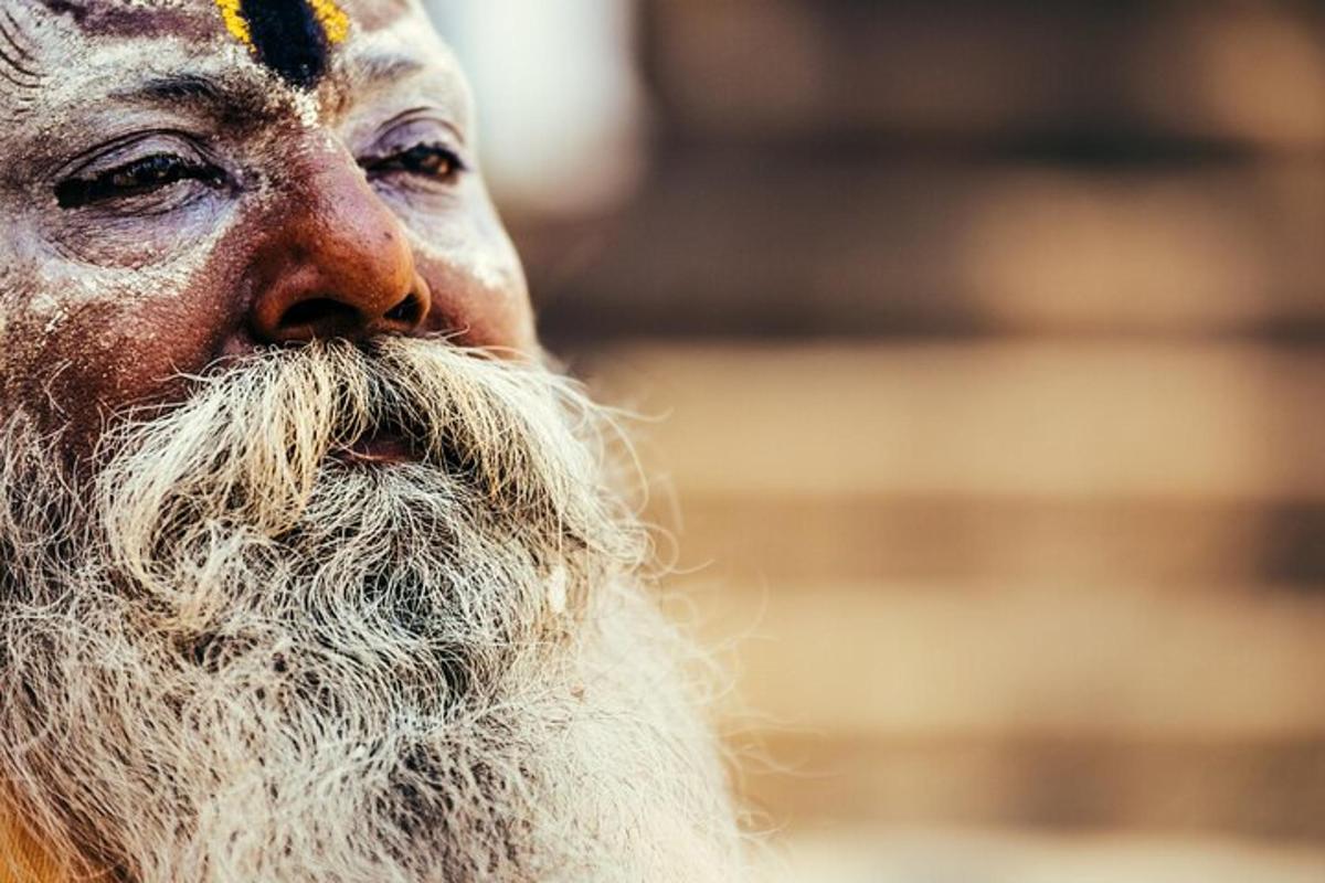 un uomo con una lunga barba bianca e la fronte gialla