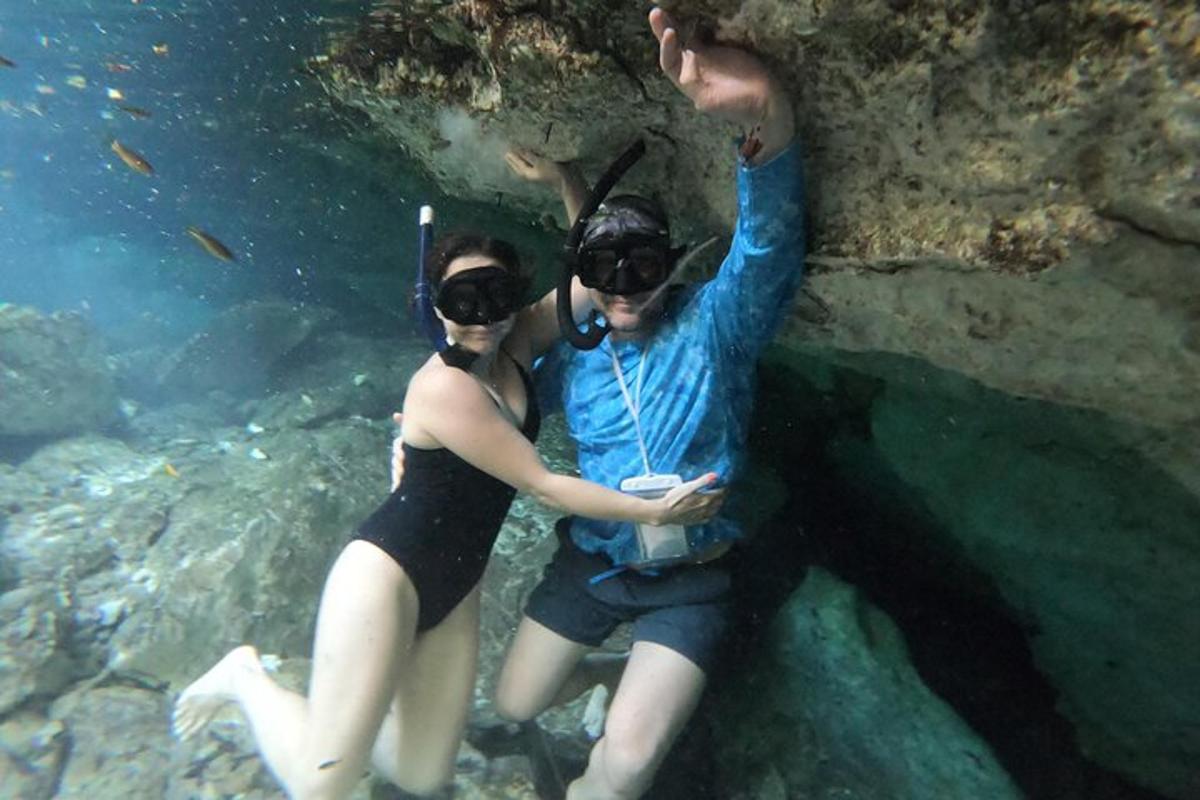 dua orang berdiri di dalam air dalam sebuah gua