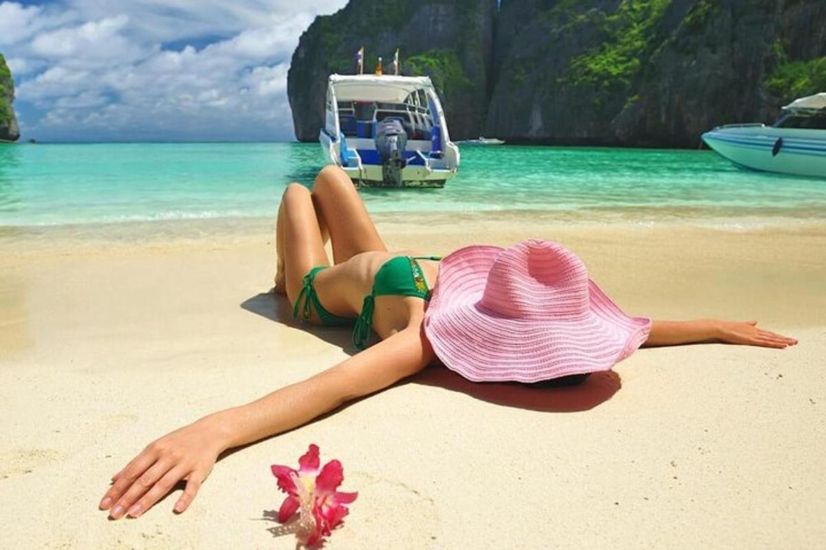 una donna con un cappello rosa sdraiata su una spiaggia