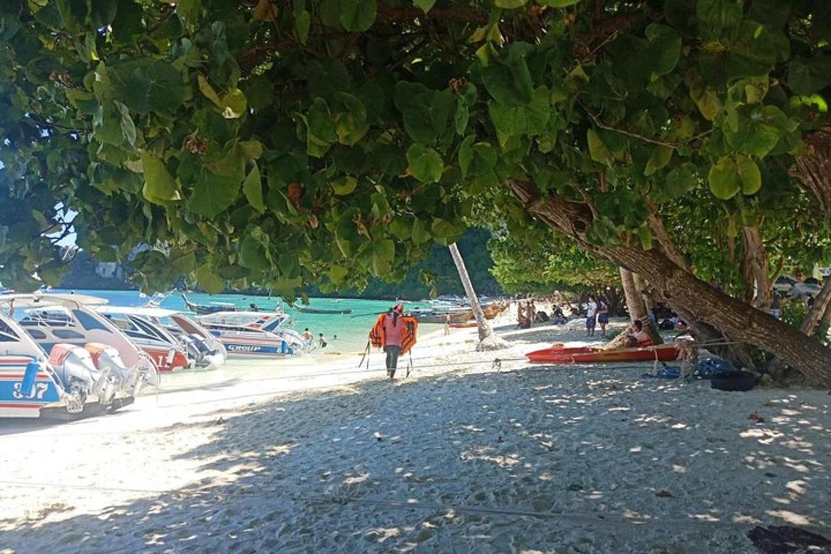 un uomo che cammina su una spiaggia con barche in acqua