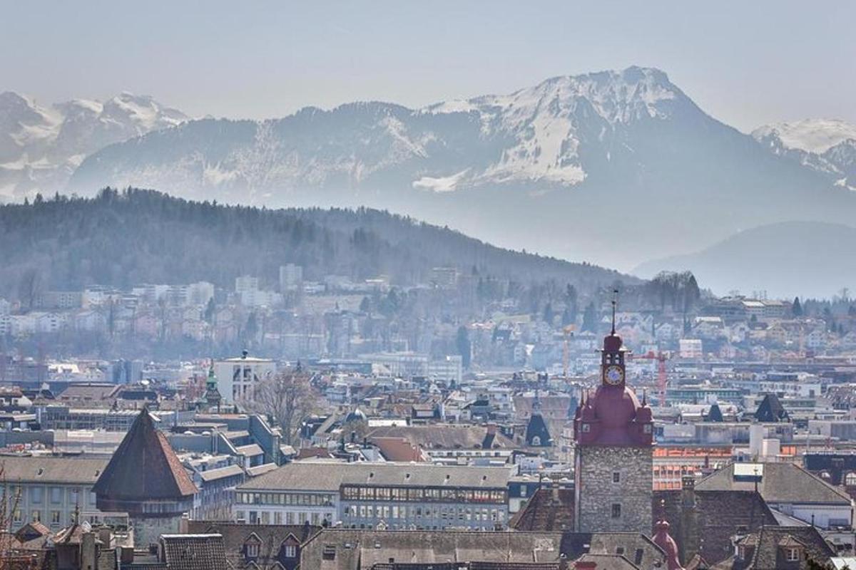 una città con una torre dell'orologio e una montagna sullo sfondo