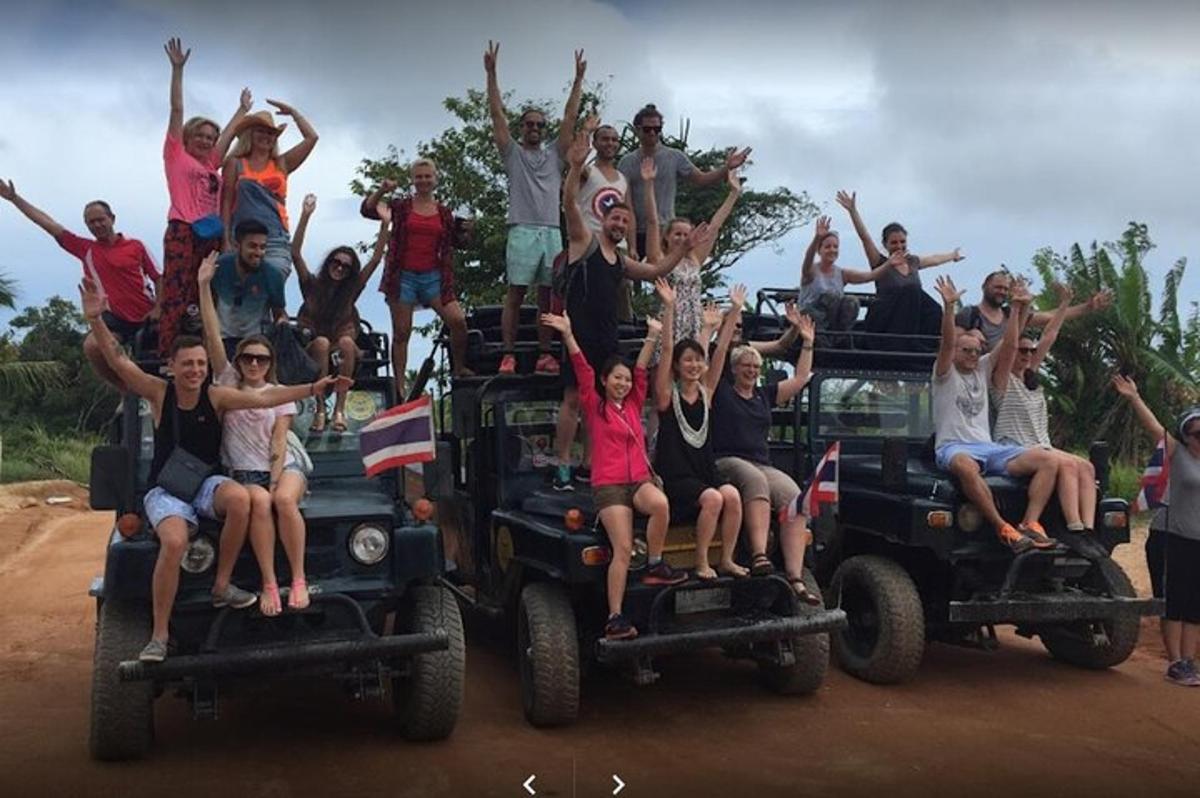 a group of people sitting on the back of jeeps