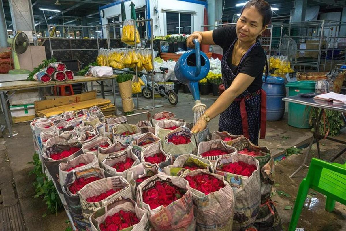 una donna in piedi davanti a una mostra di fiori