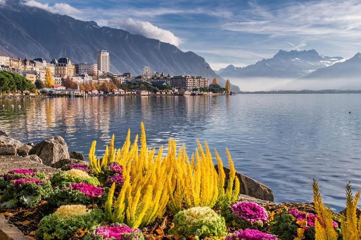 uma vista de um lago com uma cidade e flores
