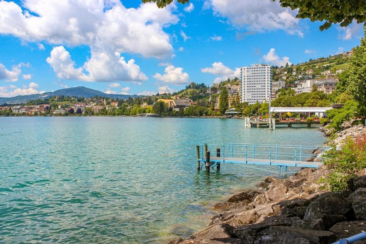 uma vista de um lago com um píer e uma cidade