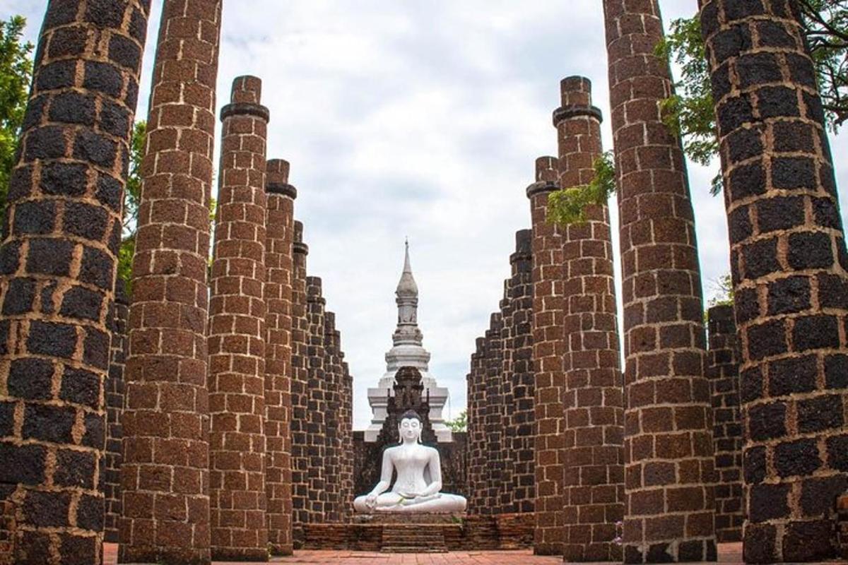 una statua di Buddha seduta sui gradini di un muro di mattoni