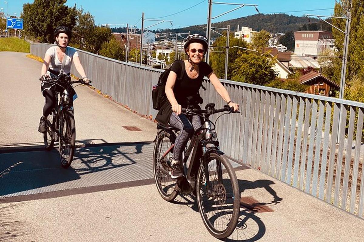 two people riding bikes on a bridge