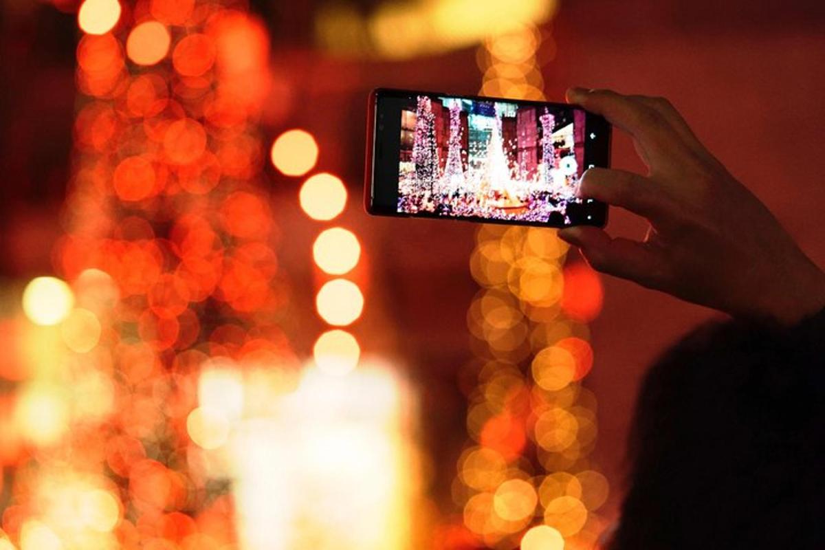 oseba, ki fotografira z mobilnim telefonom