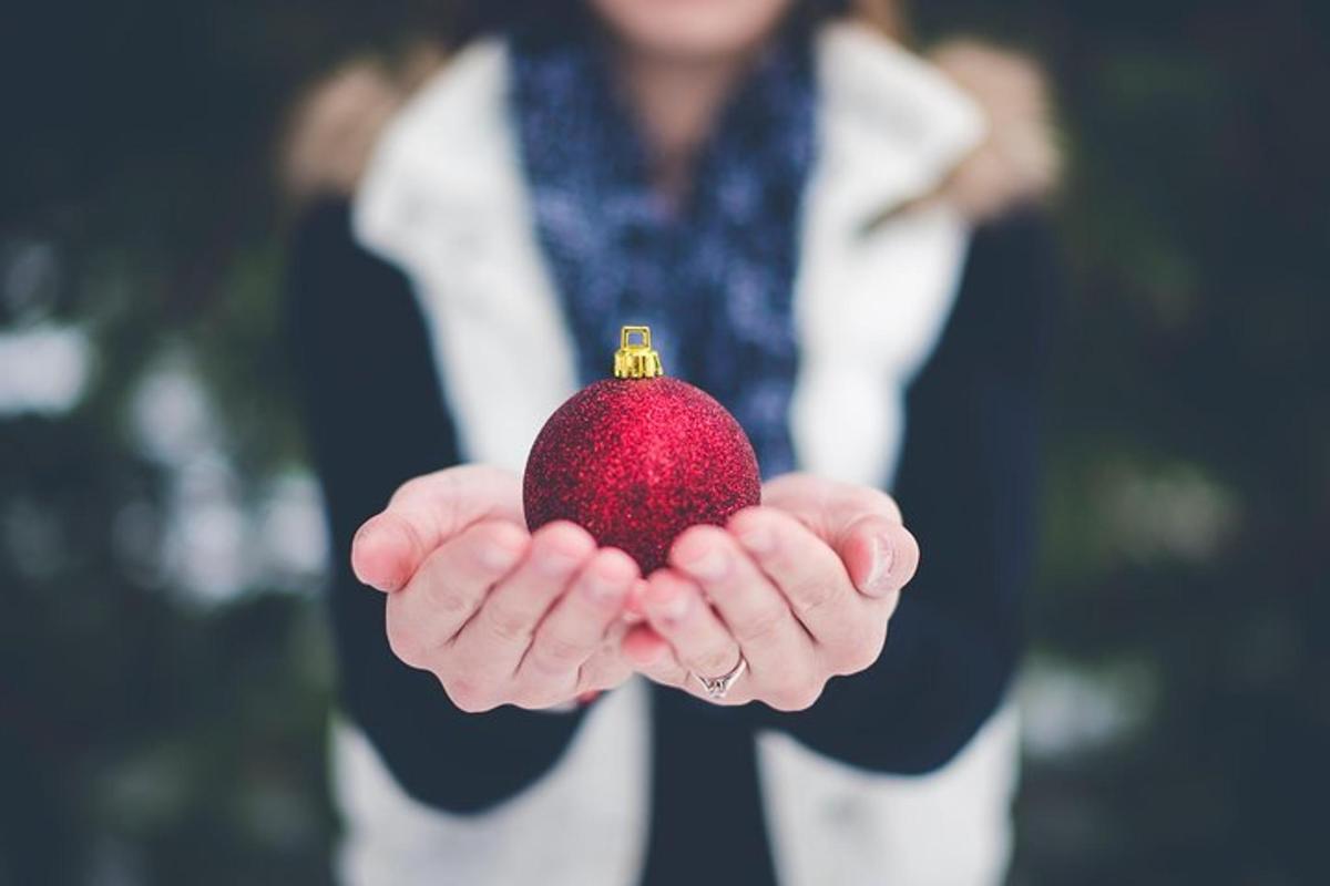 een vrouw die een rood ornament in haar handen houdt