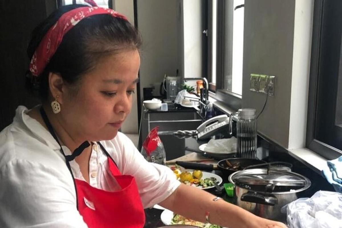 a woman standing in a kitchen preparing food