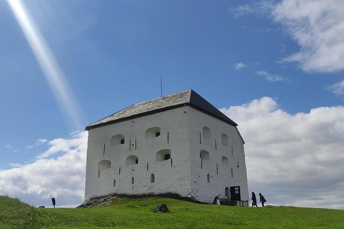 a building on a hill with a rainbow in the sky