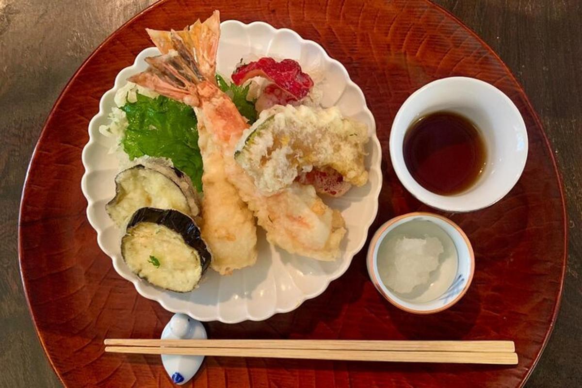 a plate of food on a wooden plate with chopsticks