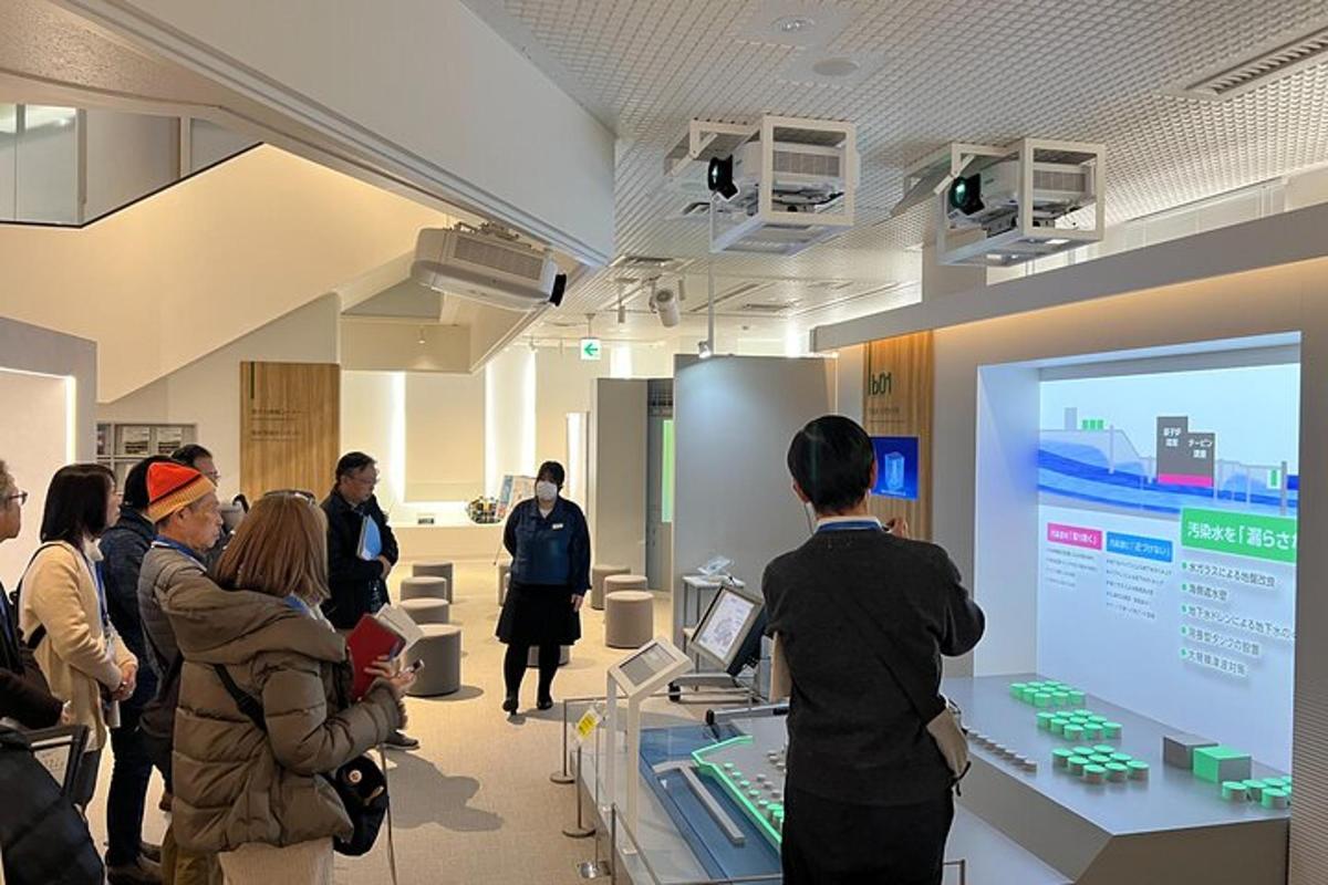 a group of people standing in a room looking at a screen