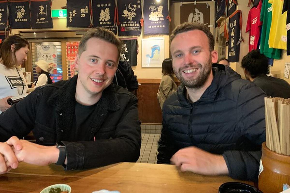 two men sitting at a table in a restaurant