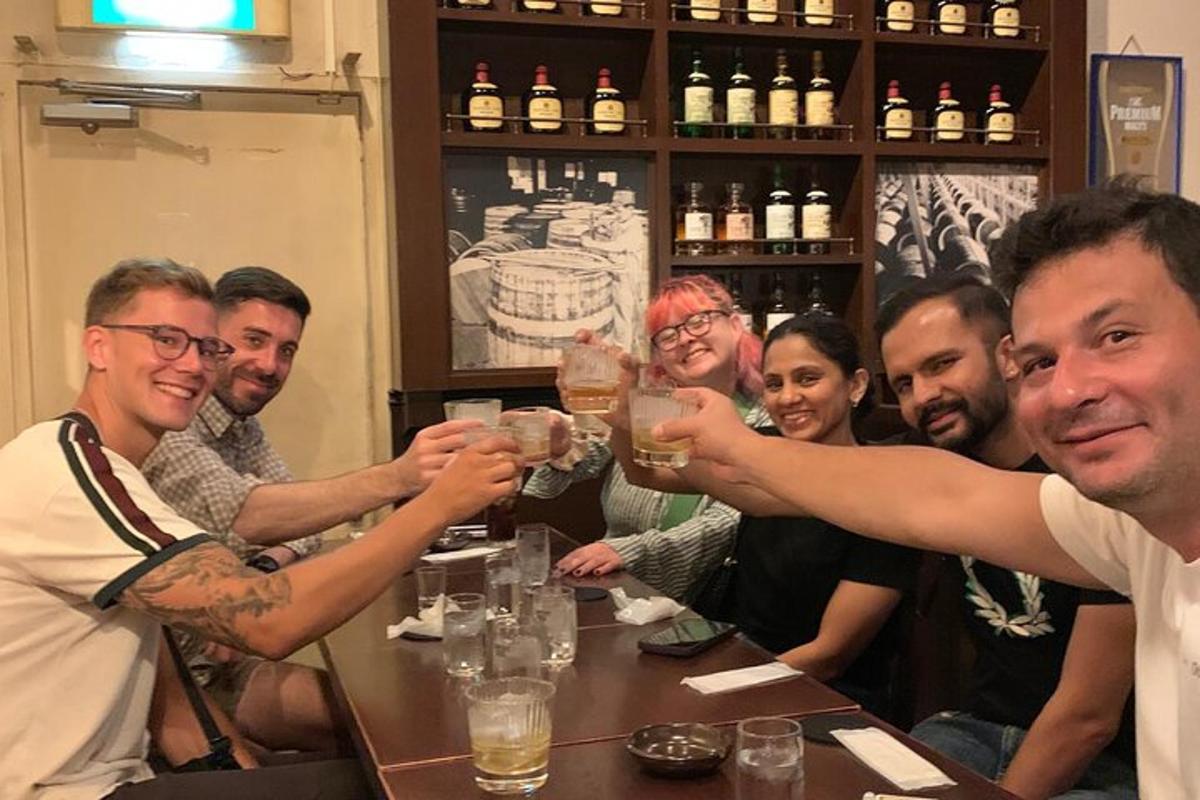a group of people sitting around a table drinking beer