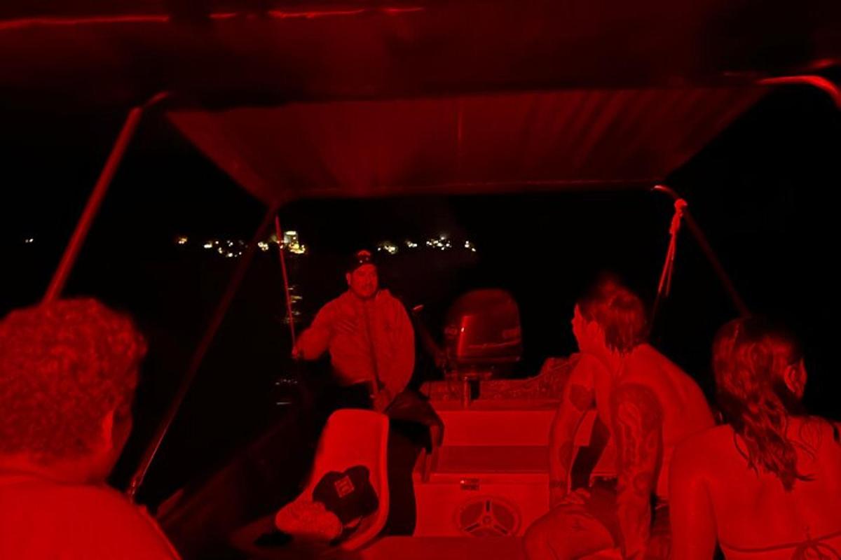 a group of people sitting in a boat at night