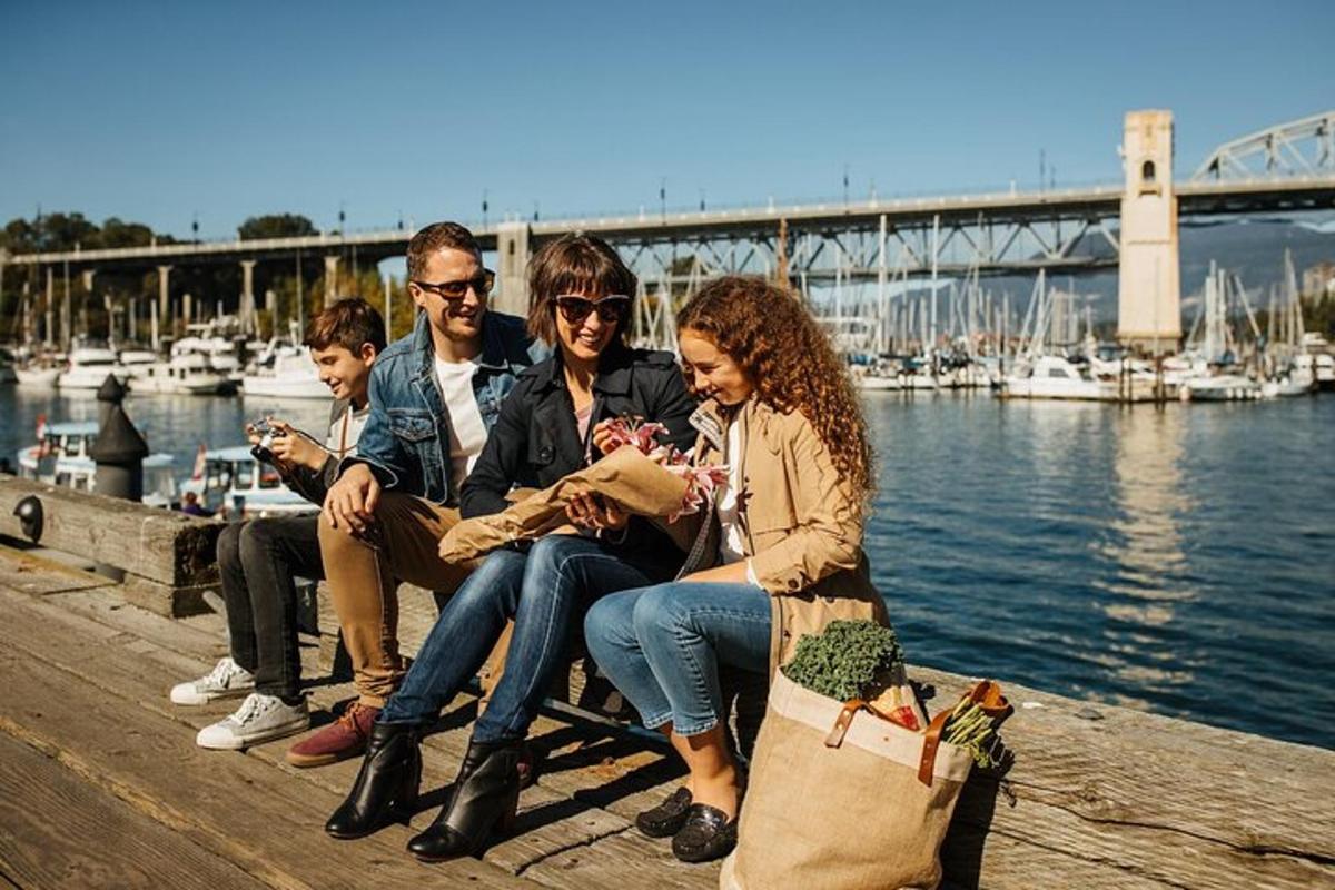 Un grupo de personas sentadas en un muelle junto al agua.