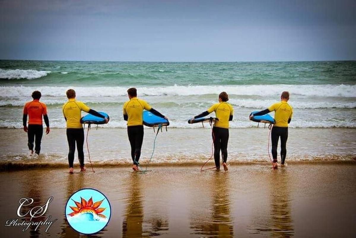 a group of people standing on the beach with surfboards