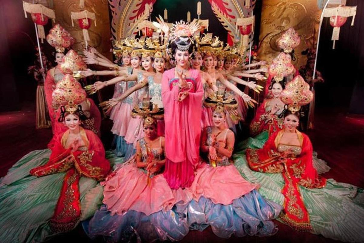 Un grupo de mujeres con vestidos sentadas en una cama.
