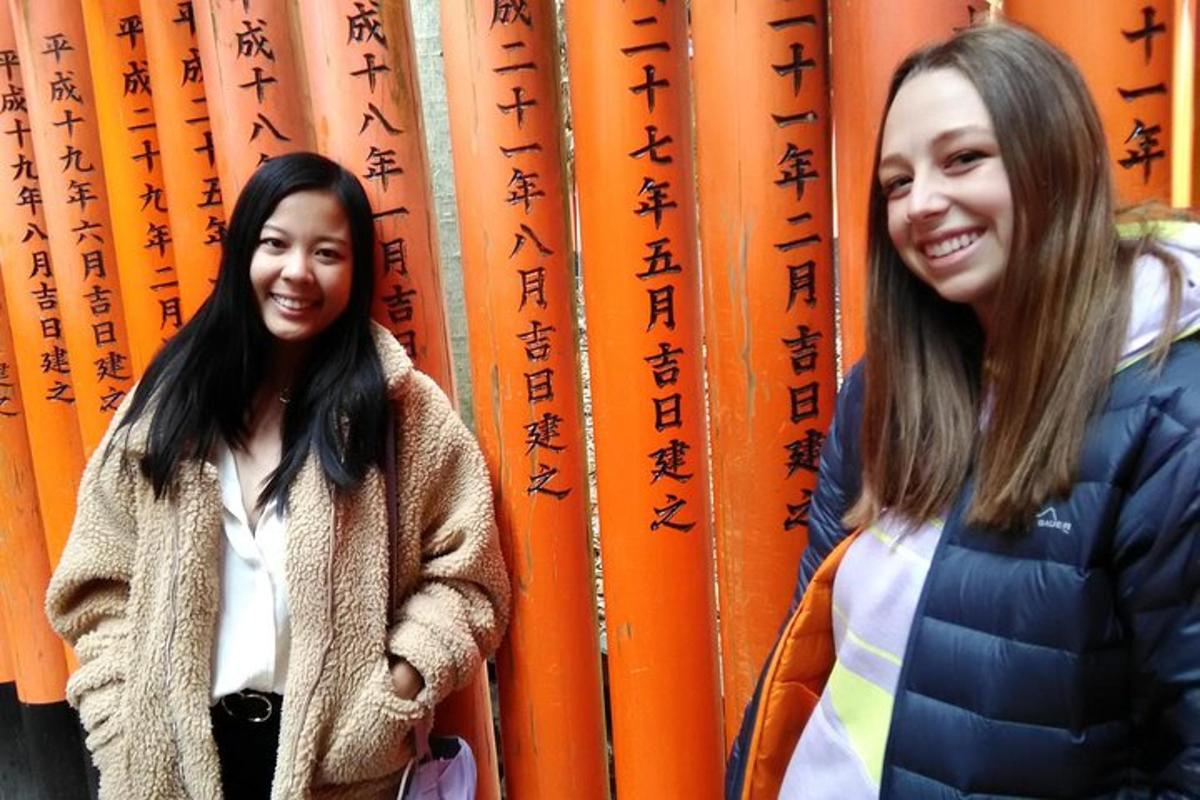 duas jovens em pé em frente a uma parede de flechas