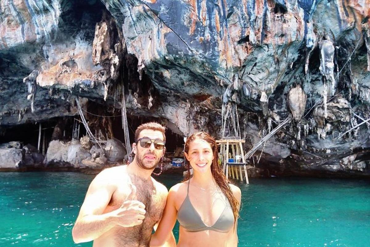 um homem e uma mulher parados na água em uma caverna