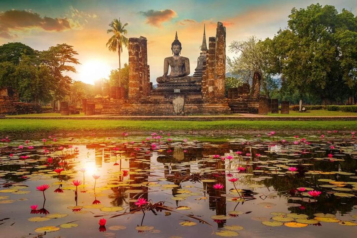 a buddha statue in a pond with flowers in front