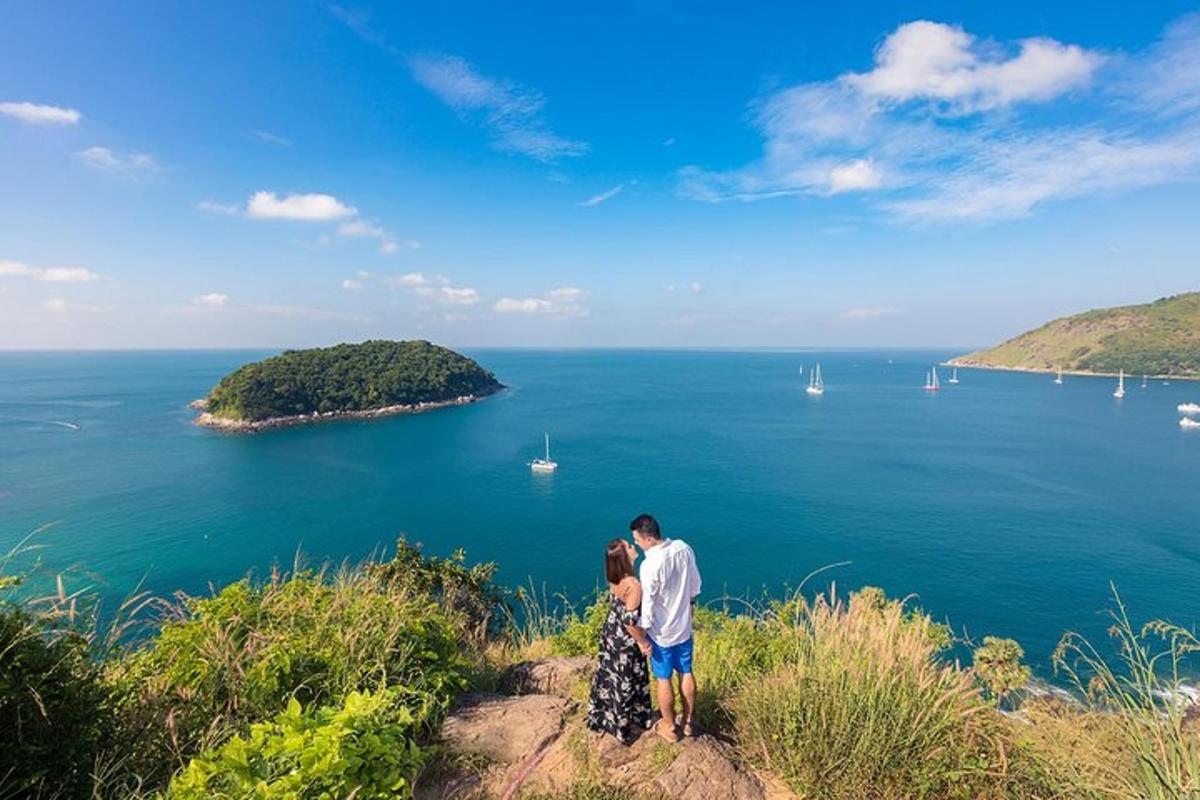moški in ženska stojita na vrhu hriba s pogledom na ocean