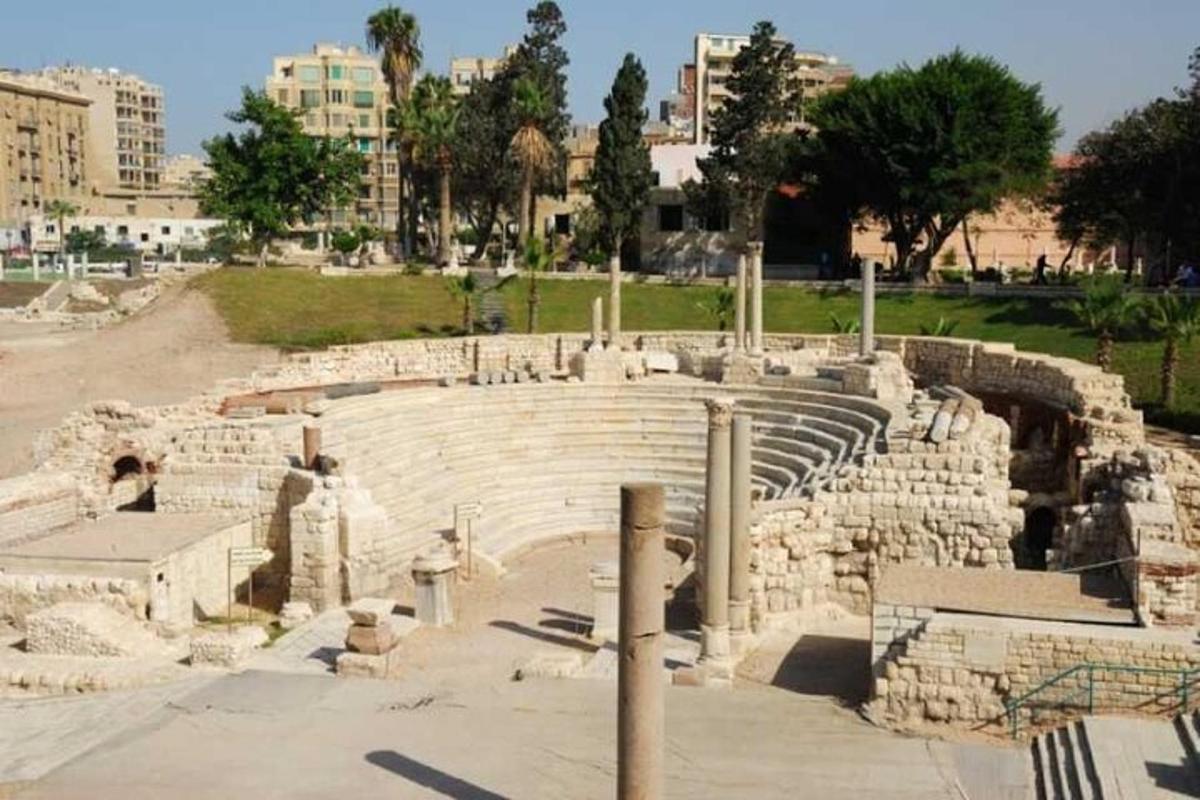 ein Amphitheater in einer Stadt mit Gebäuden im Hintergrund