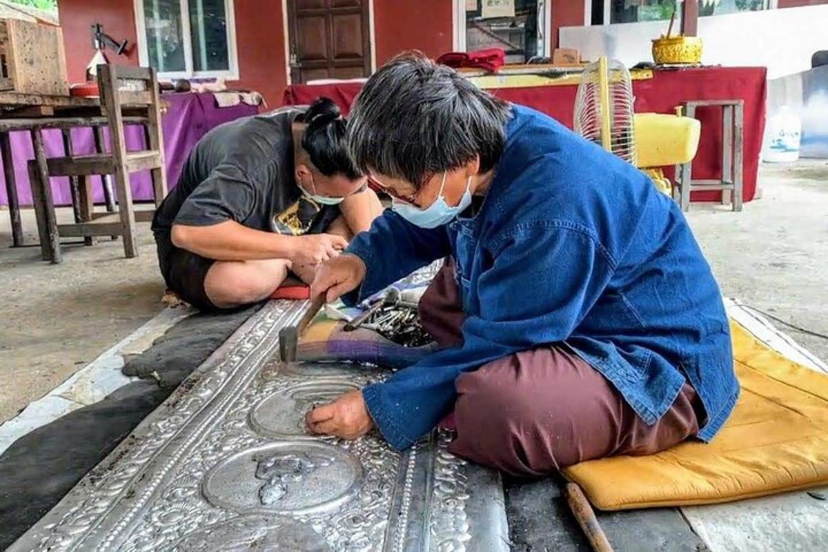 two people with a face mask working on a table