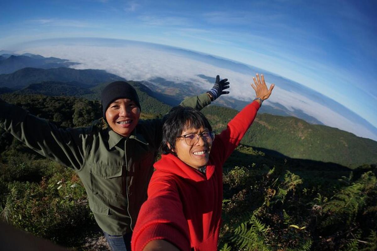 Un hombre y una mujer de pie en la cima de una montaña