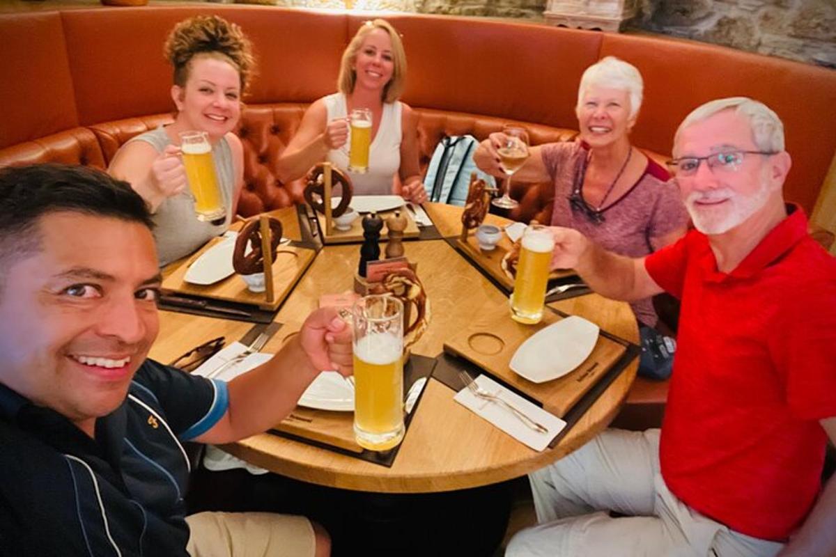 a group of people sitting around a table drinking beer