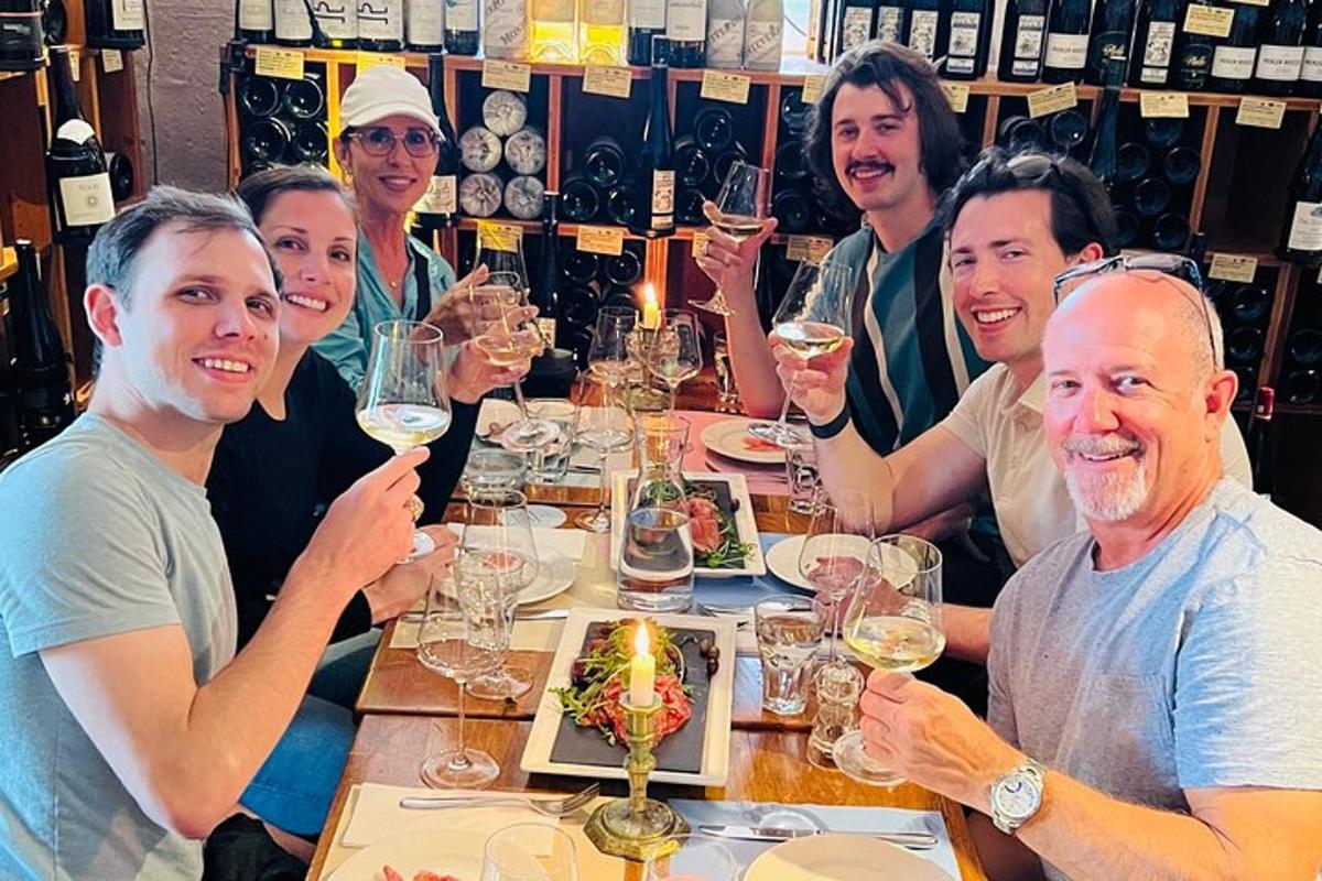 a group of people sitting around a table with wine glasses