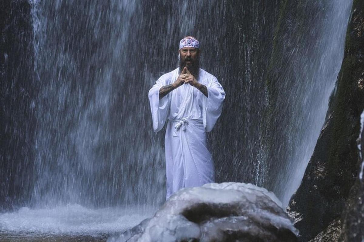 un uomo in piedi davanti a una cascata
