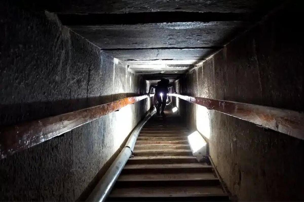 a person is walking down a dark tunnel