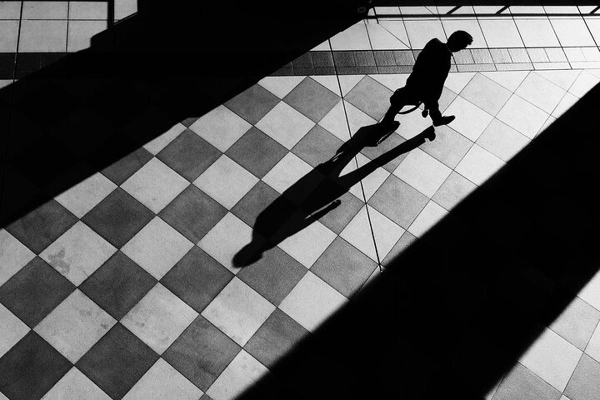 muž jedoucí na skateboardu na kostkované podlaze