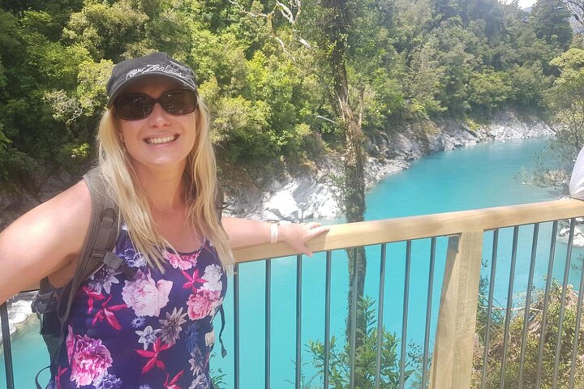 a woman standing on a balcony overlooking a blue lake