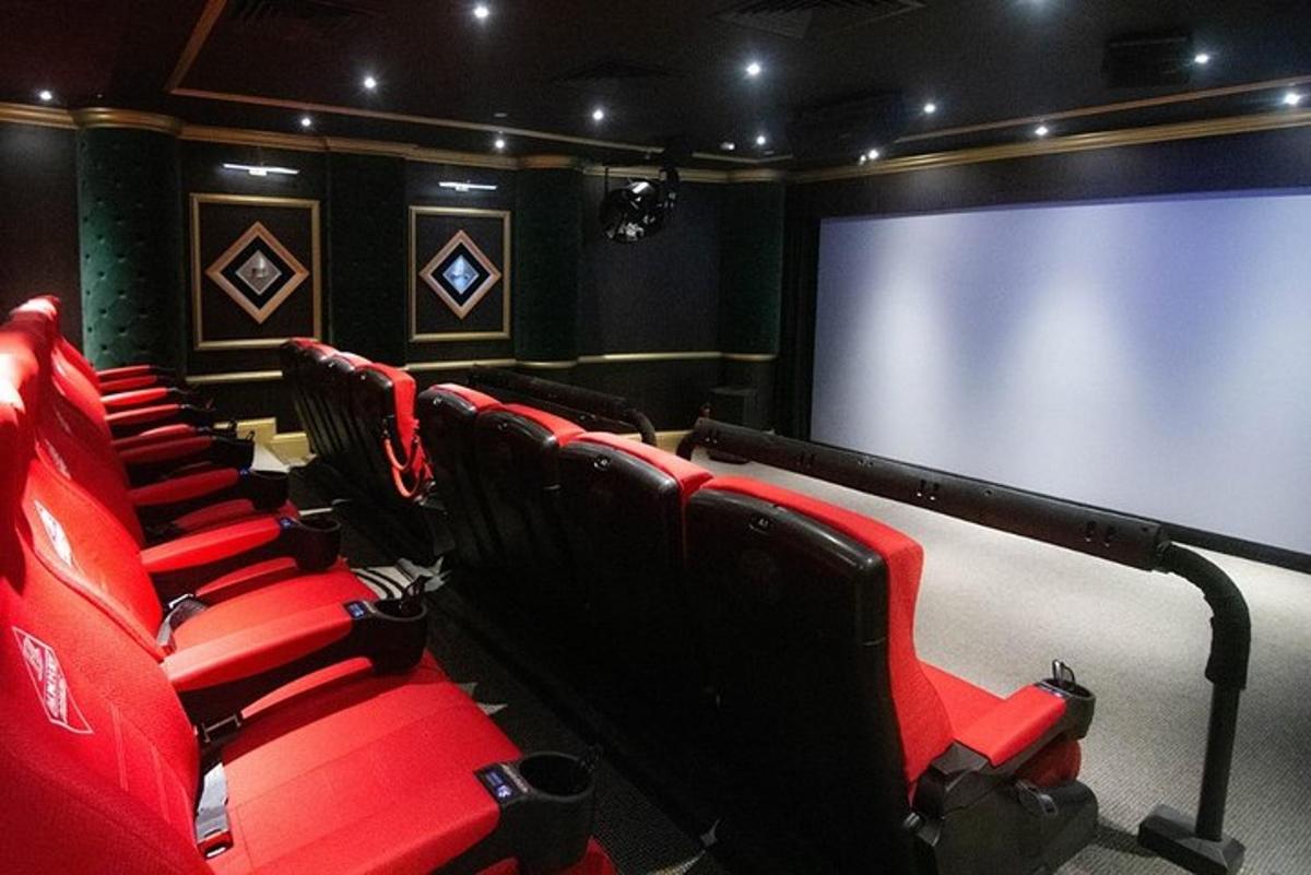 una sala de cine con asientos rojos y una pantalla