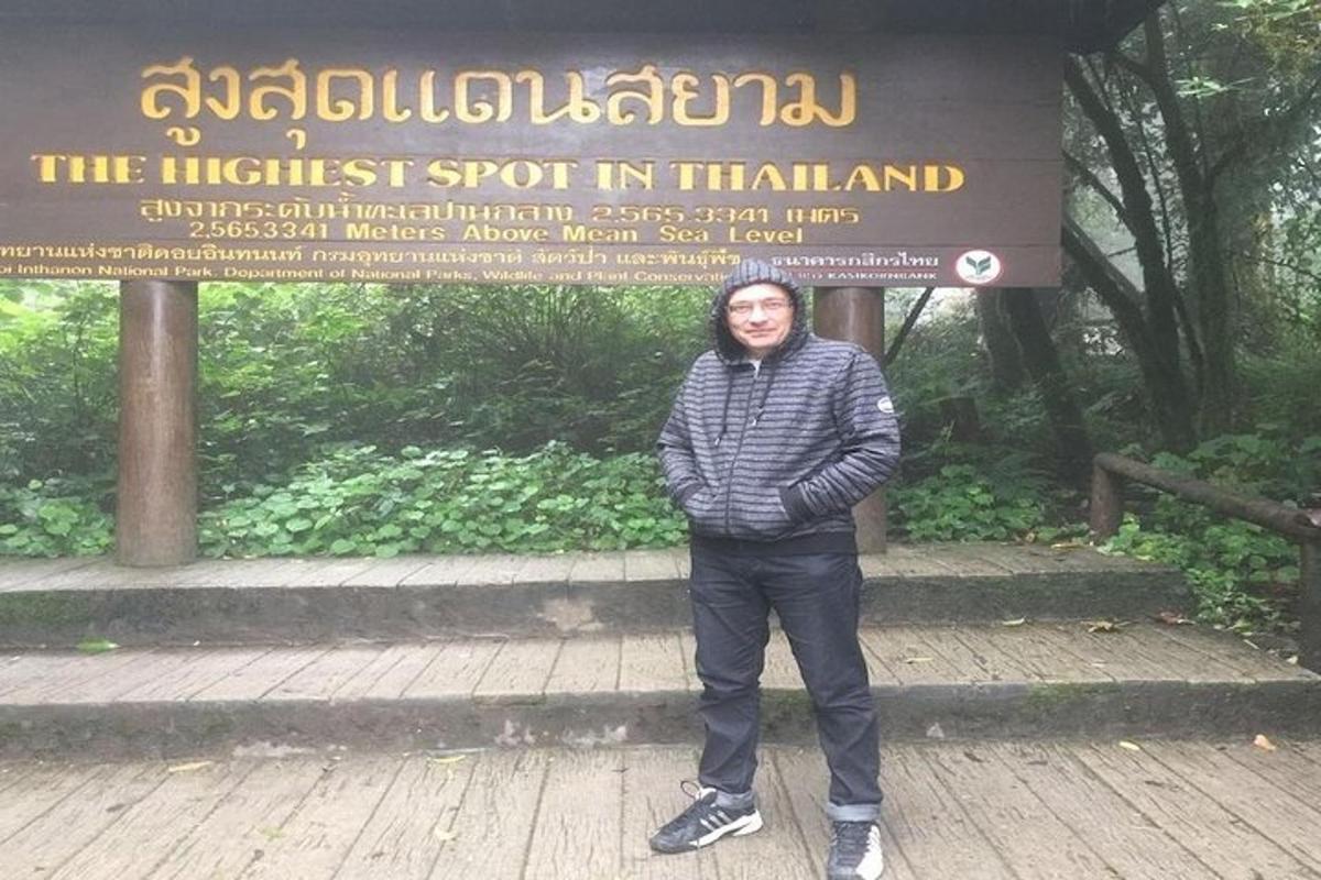 một người đàn ông đang đứng trước một biển báo