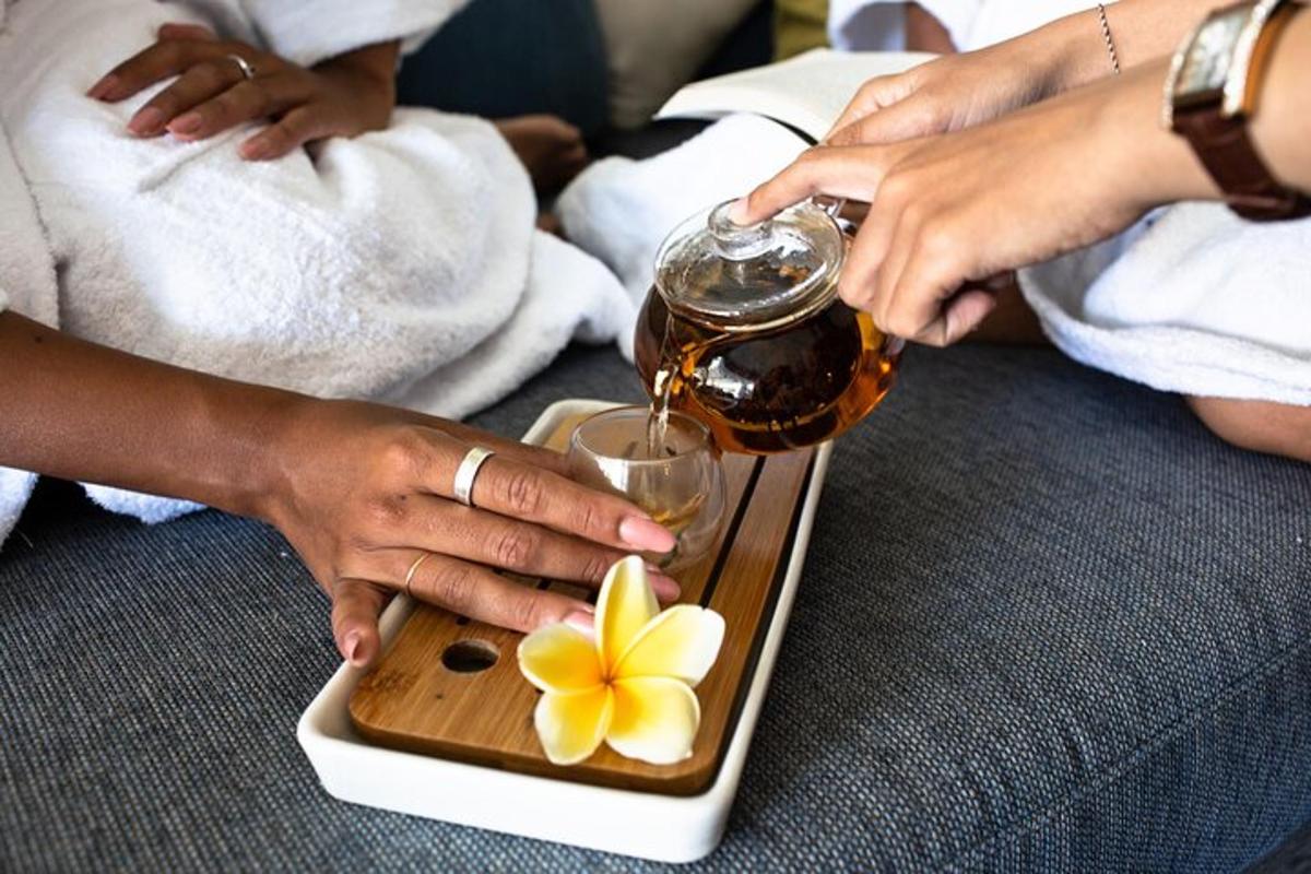 a person holding a drink and a tray with a flower on it