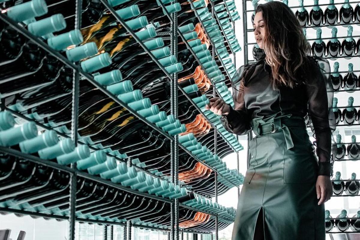 a woman standing in front of a rack of wine racks