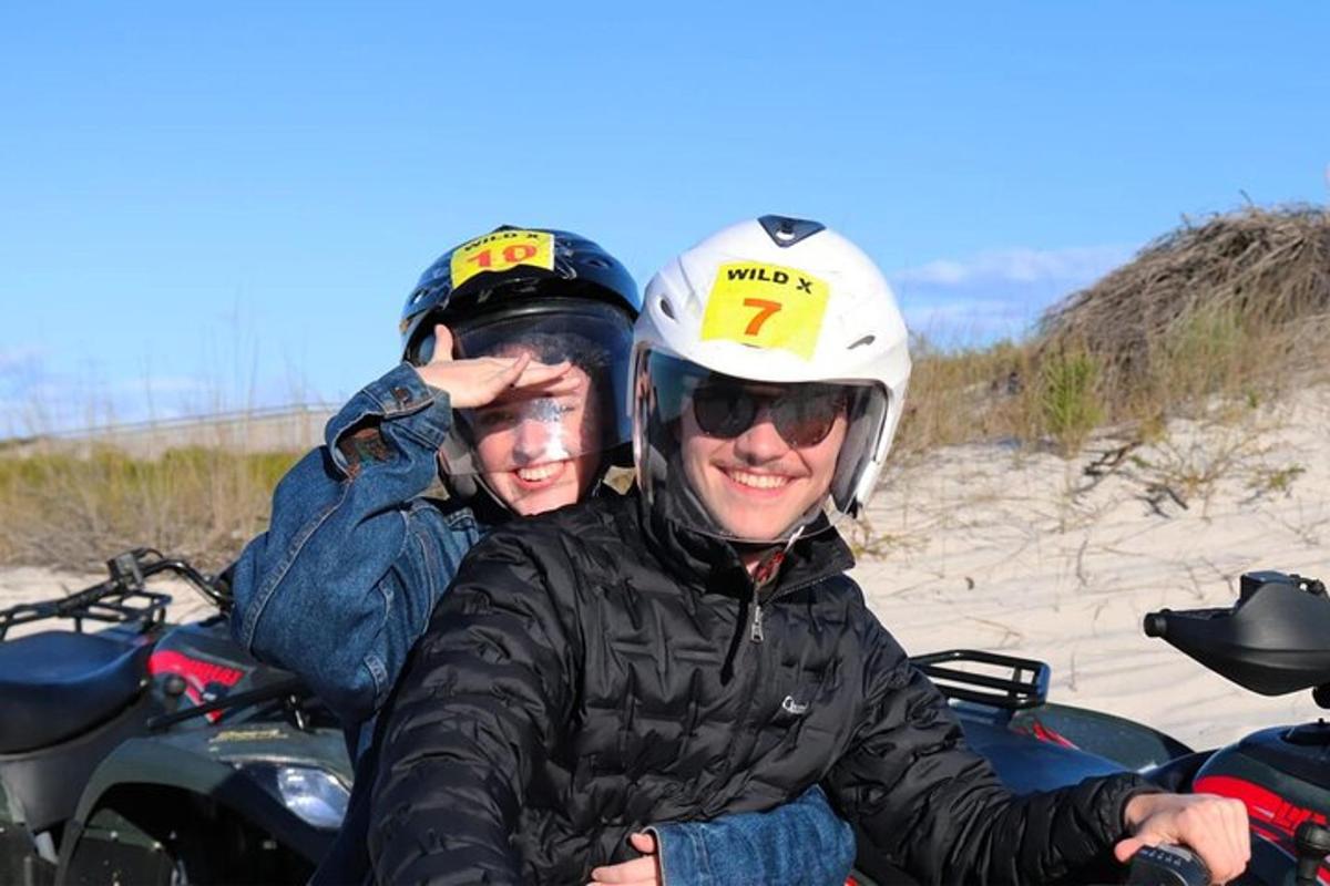 dua orang duduk di atas motosikal di pantai
