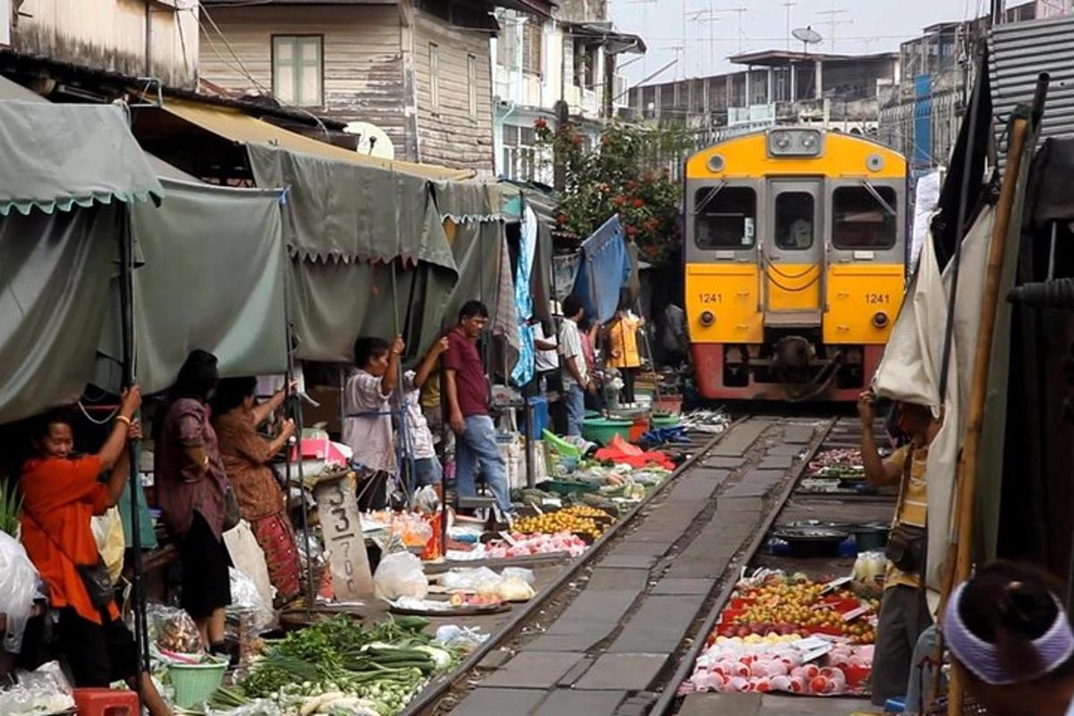 kereta api yang melalui pasar dengan orang dan sayur-sayuran