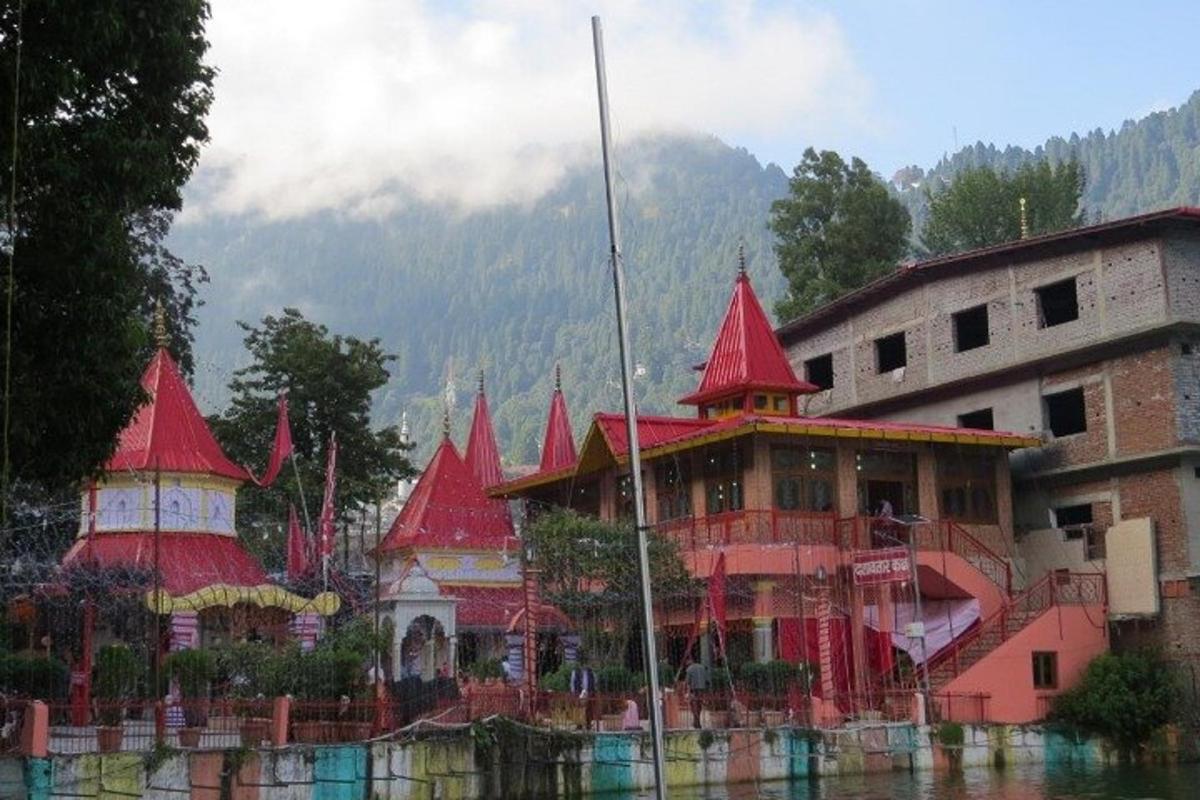 a building with red roofs on the water next to a building