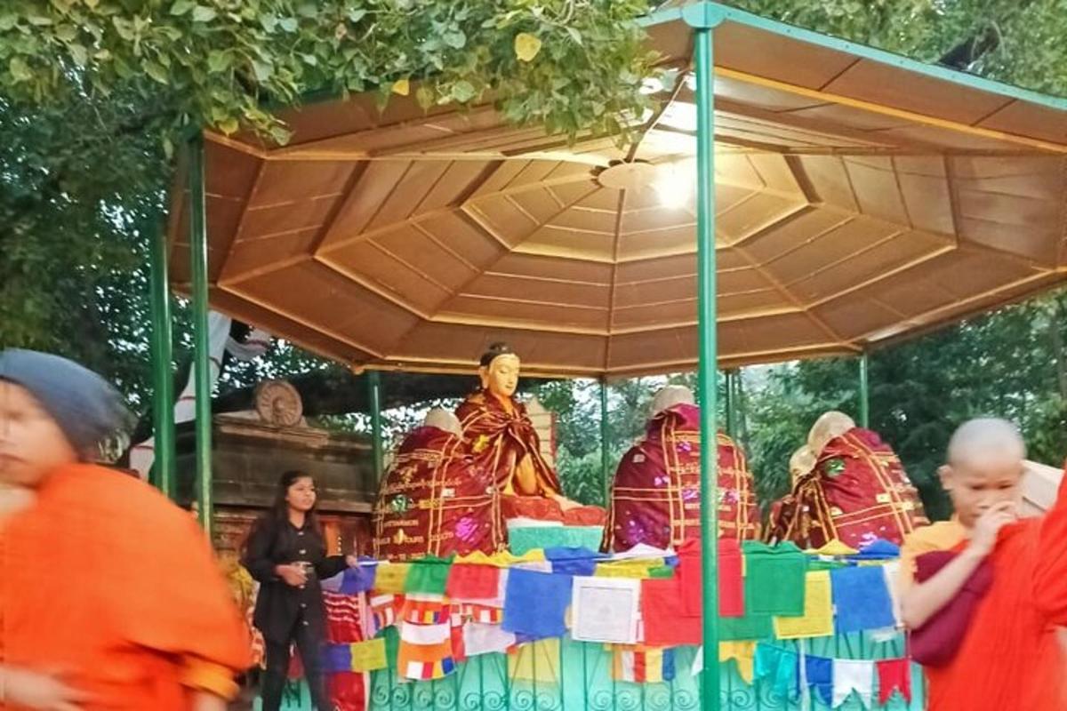 sekumpulan orang berdiri di sekeliling meja dengan patung