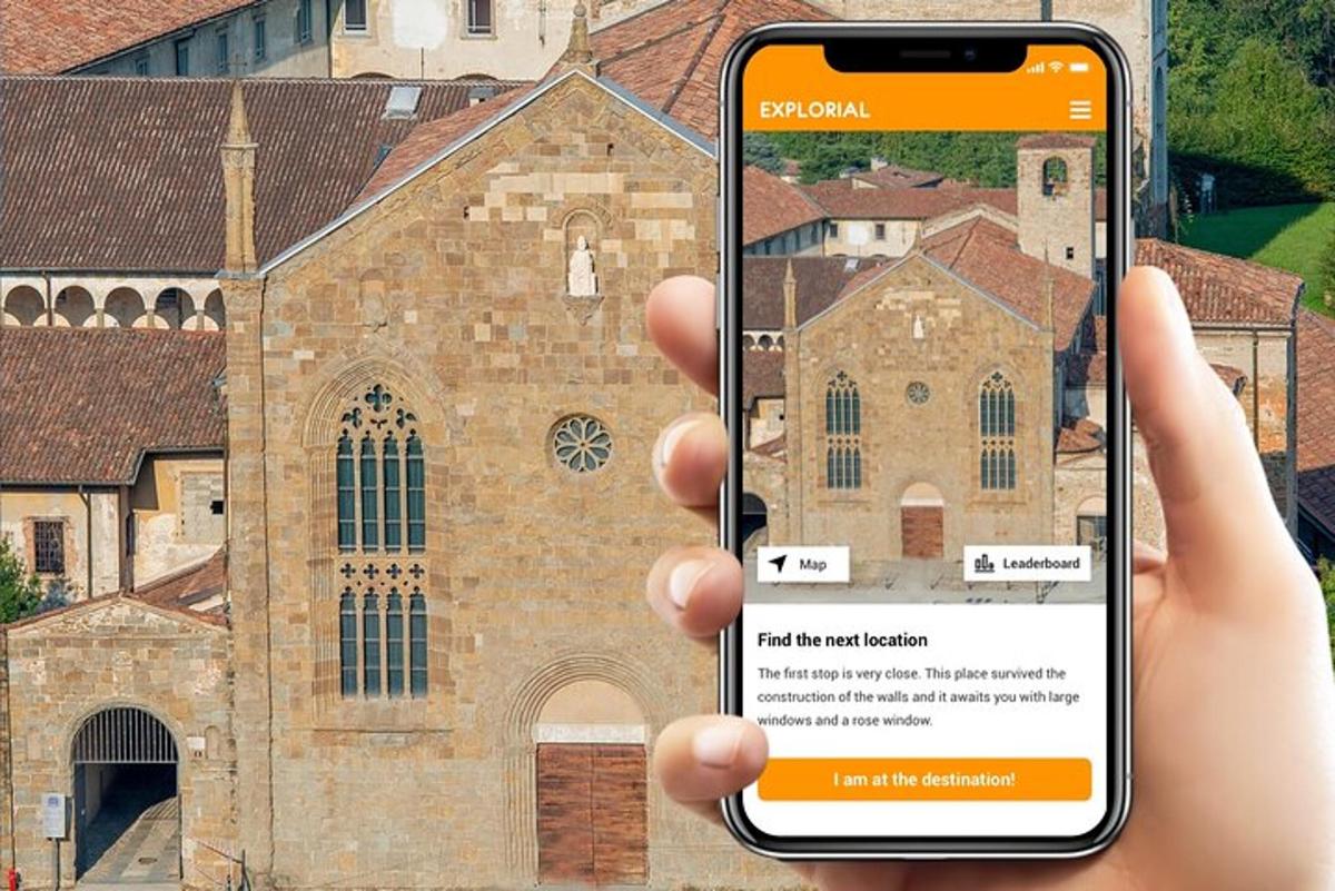 una persona que sosté un telèfon mòbil davant d'una església