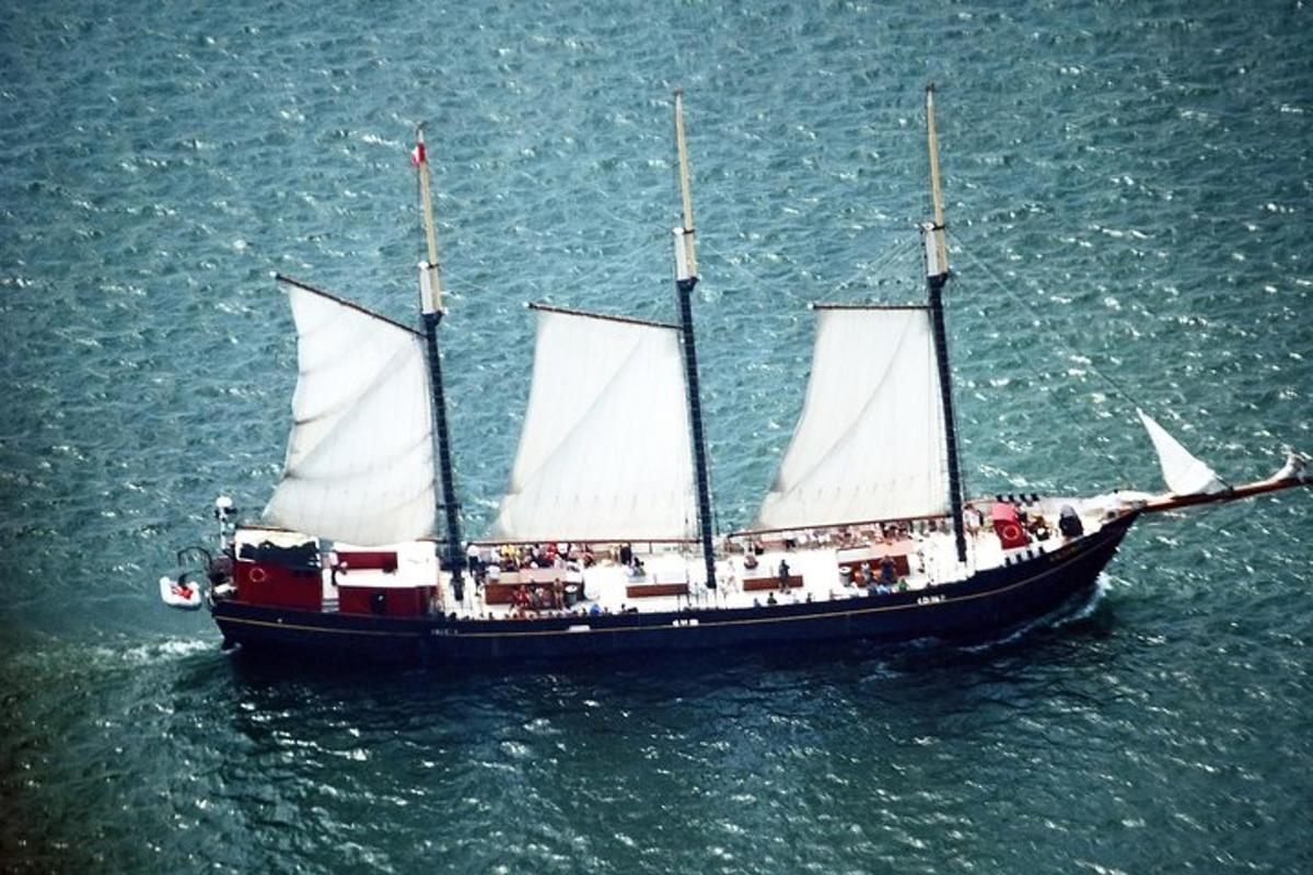 a large boat with white sails in the water