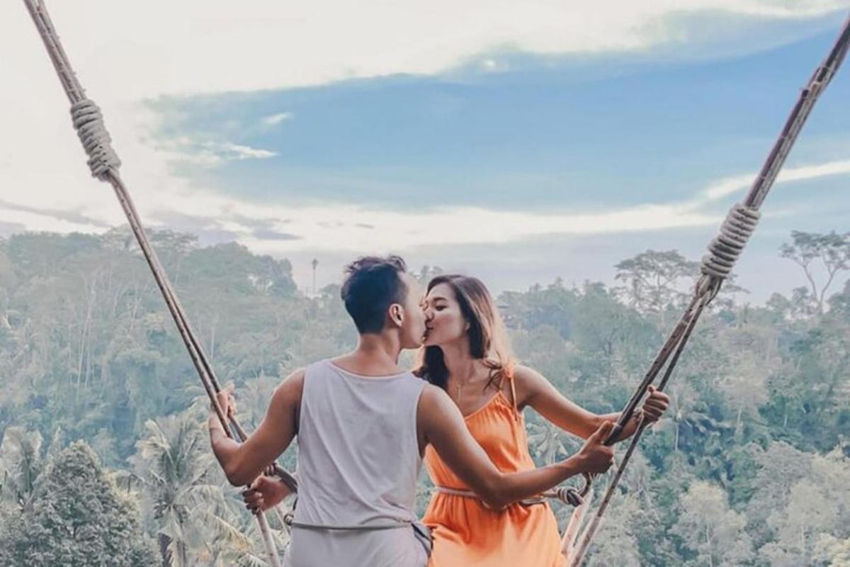 a man and a woman sitting on a swing