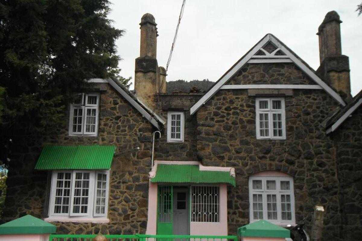 an old stone house with white windows and green shutters